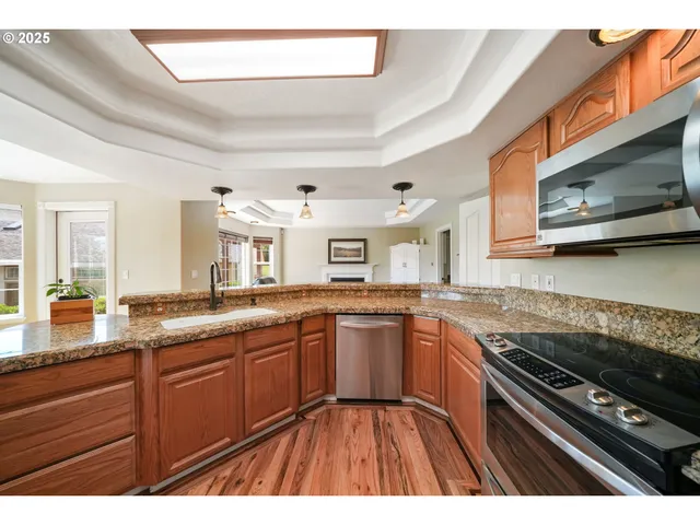 a kitchen with stainless steel appliances granite countertop a sink and wooden cabinets