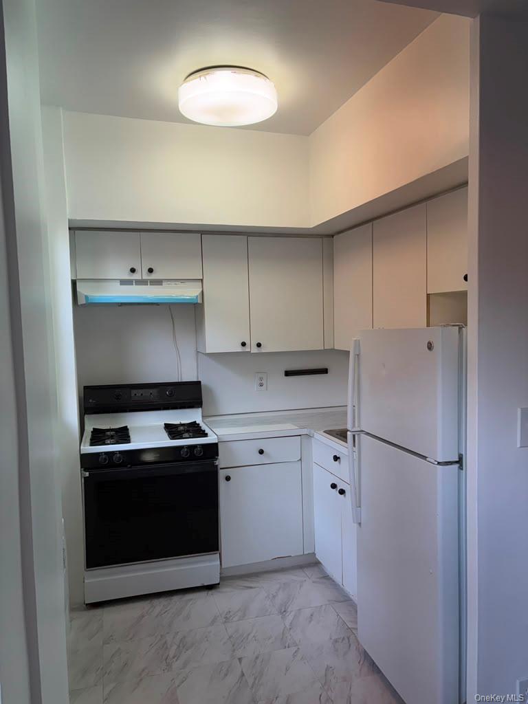 99-60 63rd Road, Unit 1H Queens, NY 11374 - Photo 11 of 11 a kitchen with stainless steel appliances a stove and a refrigerator