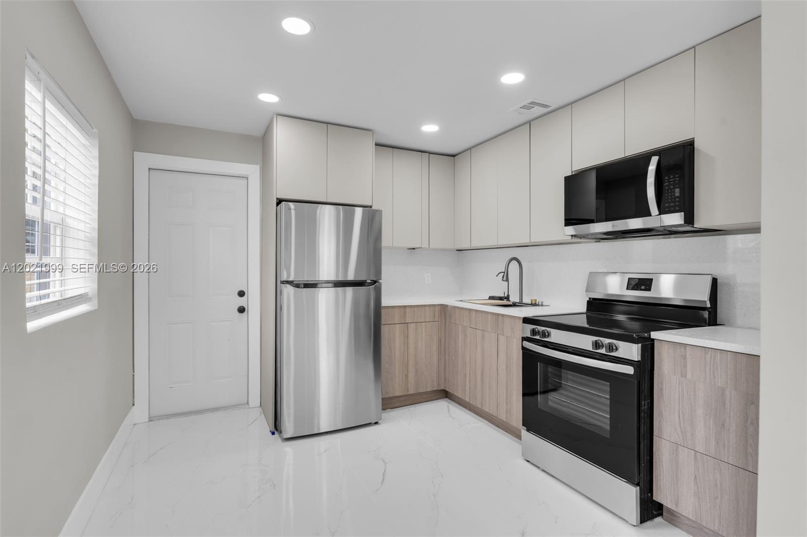 1660 West 26th Street Riviera Beach, FL 33404 - Photo 8 of 28 a kitchen with stainless steel appliances a refrigerator stove and microwave