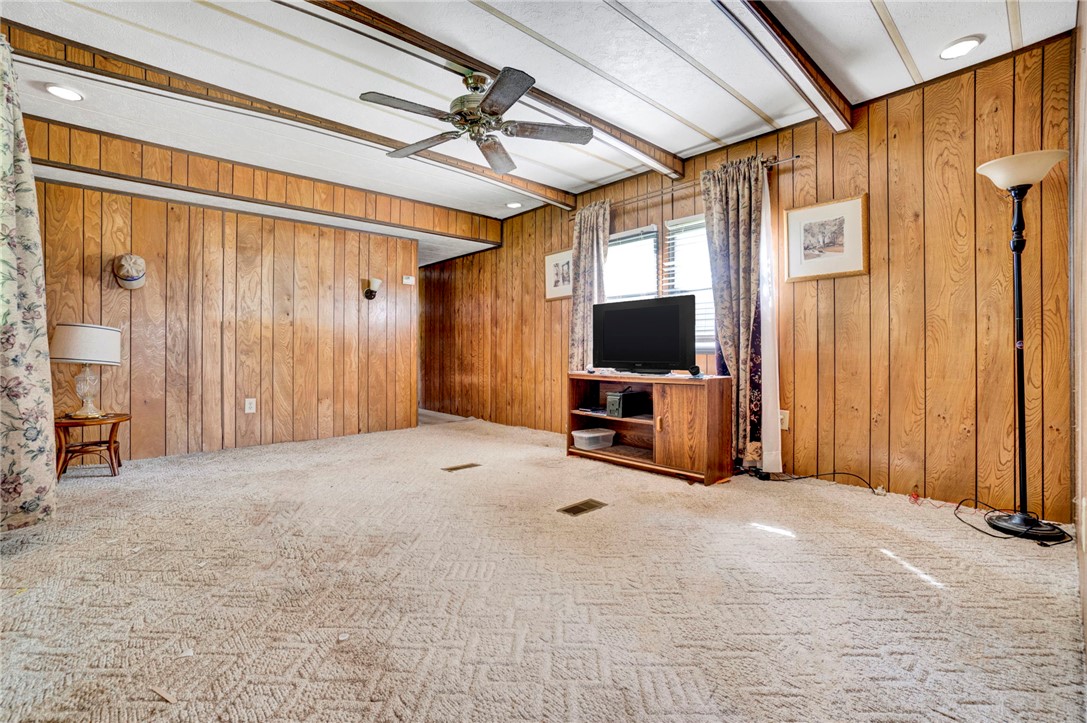 1504 Park Ridge Drive Seneca, SC 29672 - Photo 13 of 16 Warm wood paneling and textured carpeting define this cozy living space with beamed ceilings.