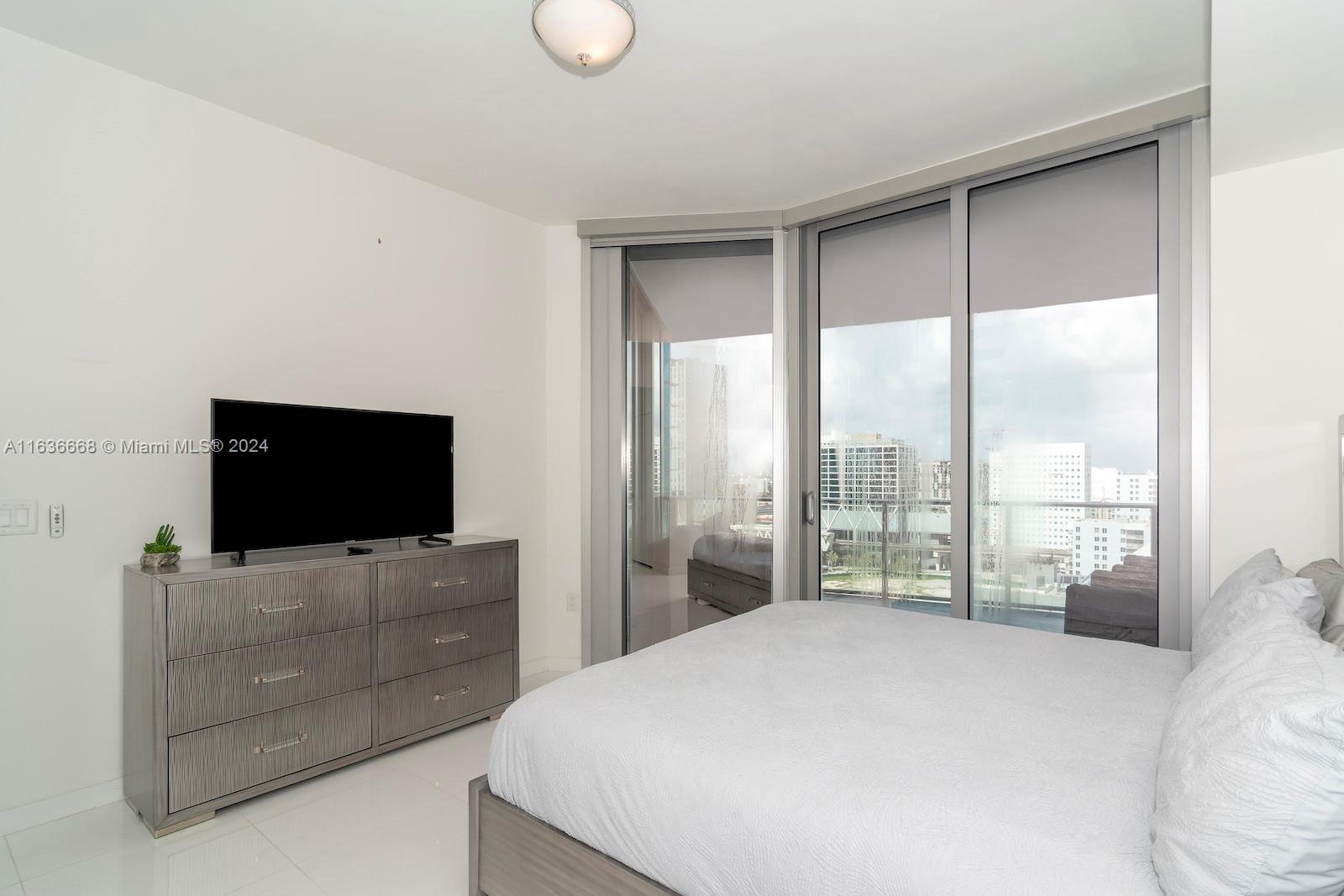 851 Northeast 1st Avenue, Unit 1710 Miami, FL 33132 - Photo 15 of 26 a bedroom with a bed and a flat screen tv