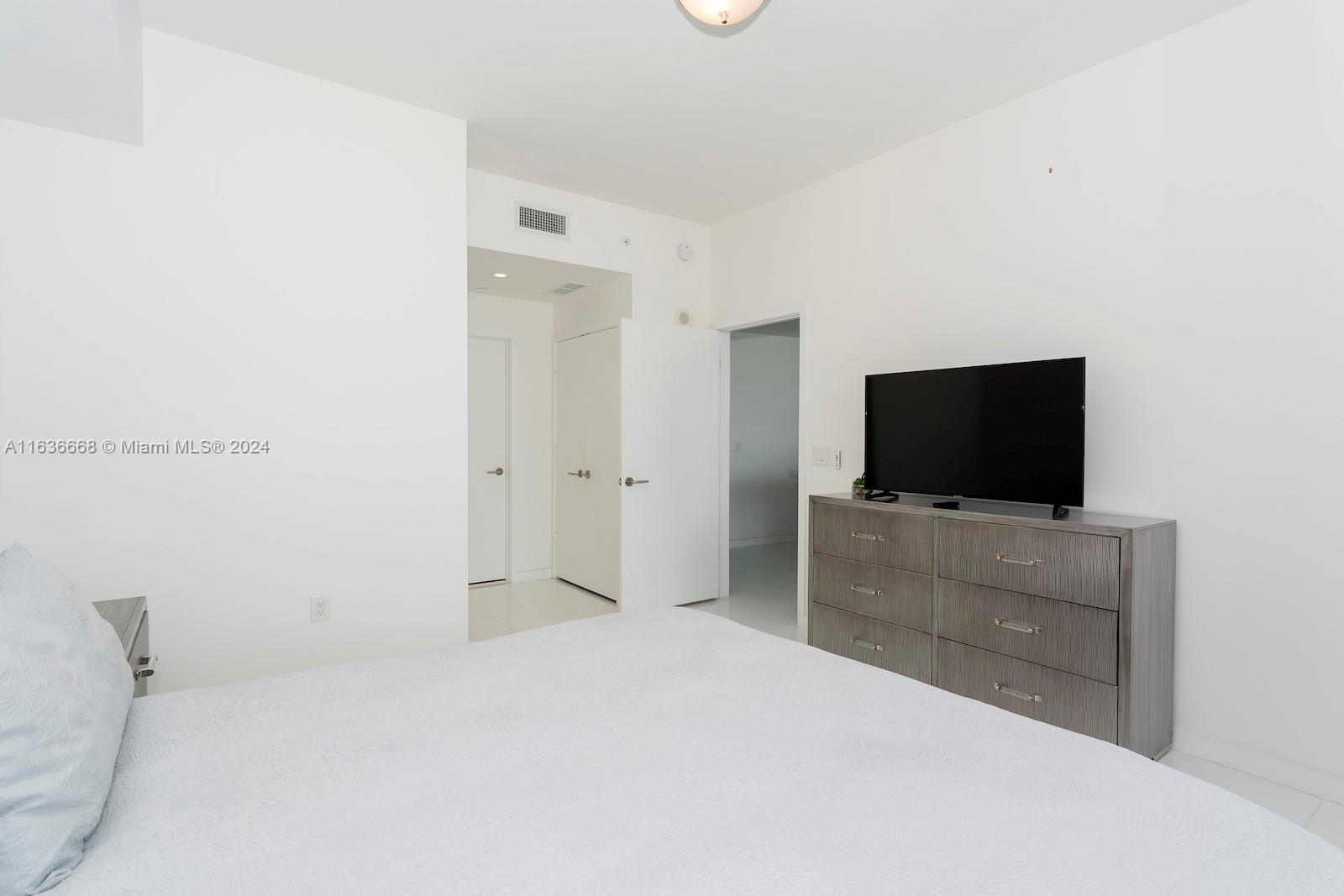 851 Northeast 1st Avenue, Unit 1710 Miami, FL 33132 - Photo 16 of 26 a bedroom with a bed and a flat screen tv