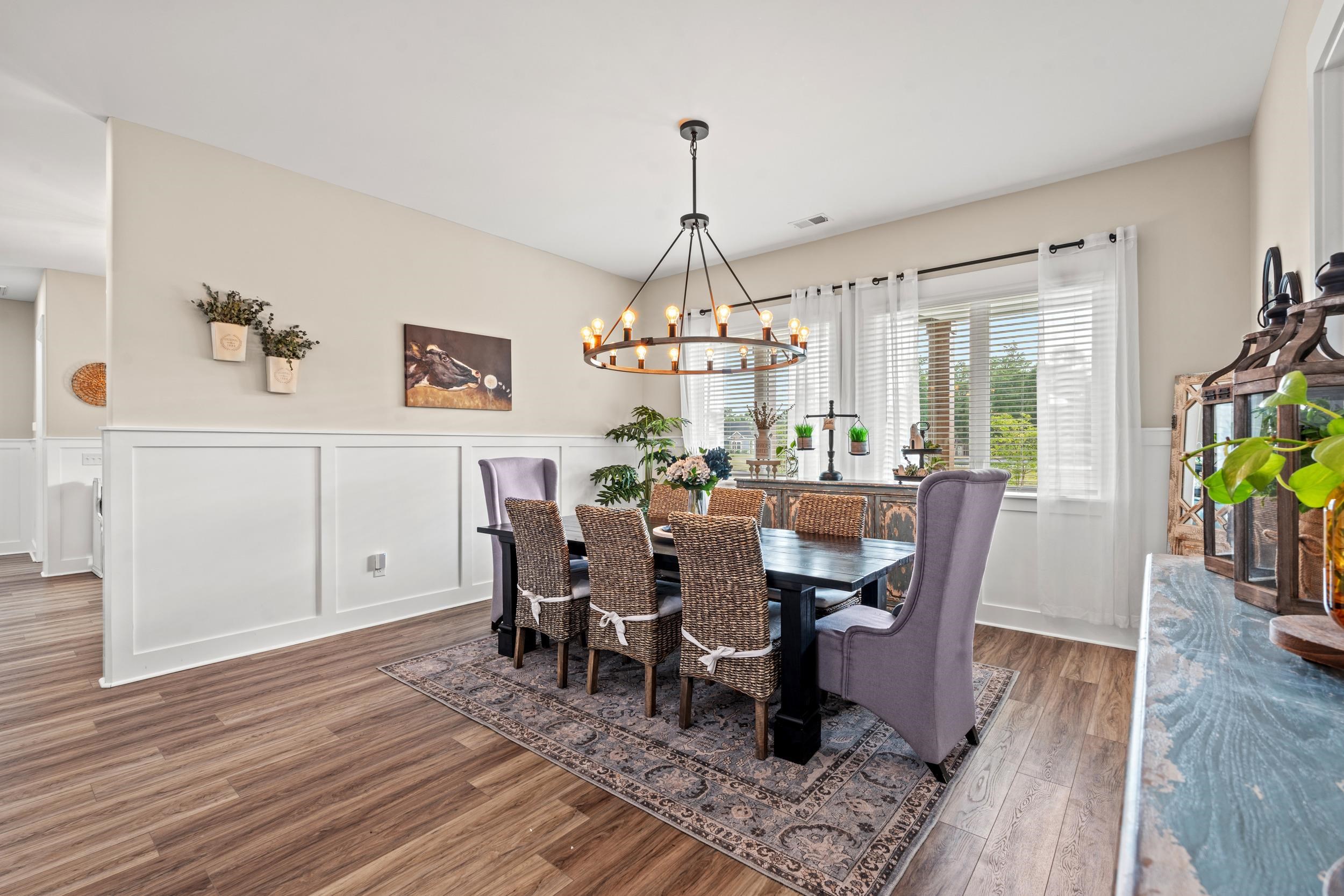 411 Chamberlin Road Myrtle Beach, SC 29588 - Photo 12 of 40 Dining area with a wainscoted wall, a decorative wall, wood finished floors, and a chandelier