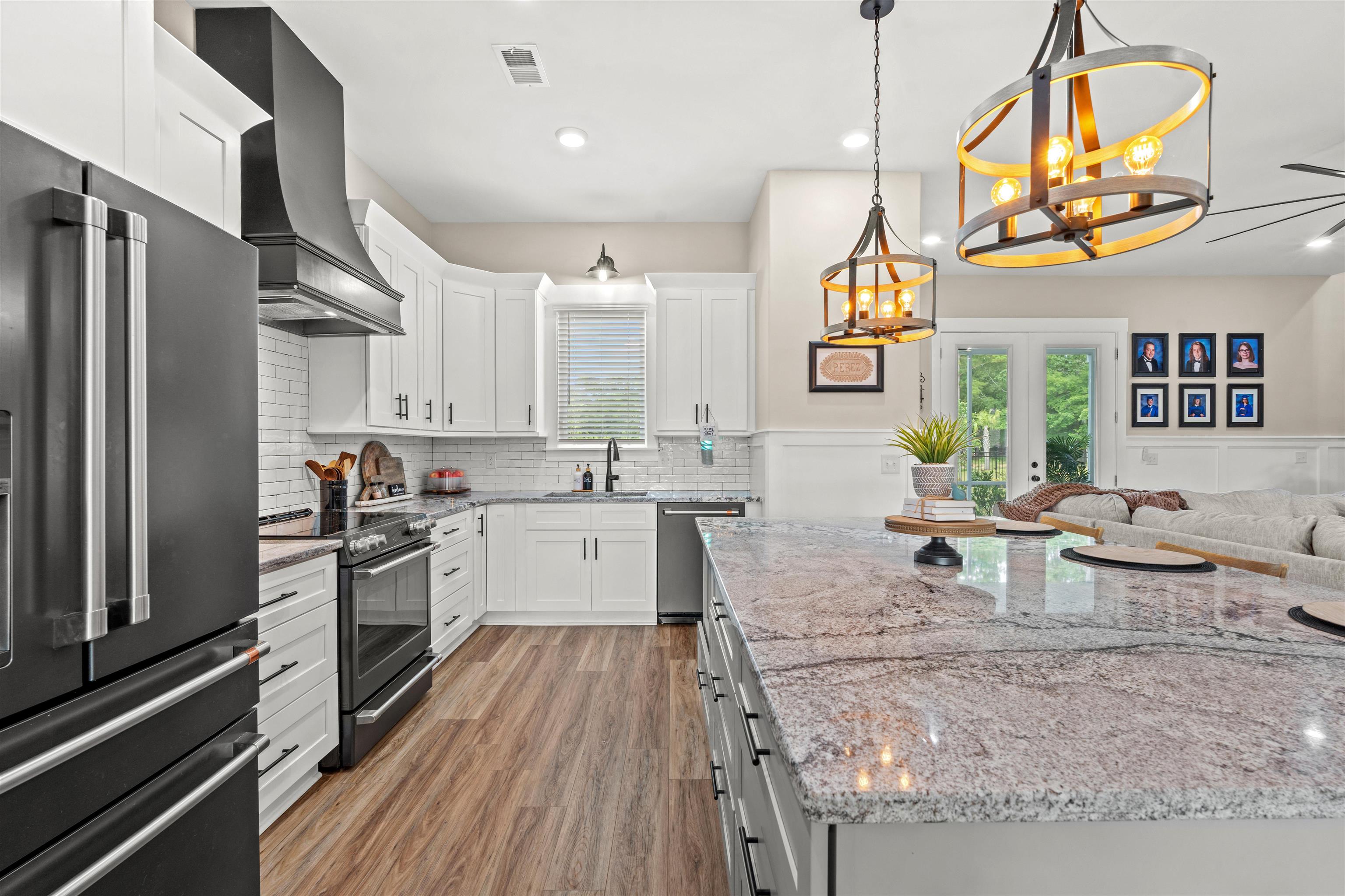 411 Chamberlin Road Myrtle Beach, SC 29588 - Photo 8 of 40 Kitchen with high end fridge, light stone counters, electric range, white cabinetry, and recessed lighting