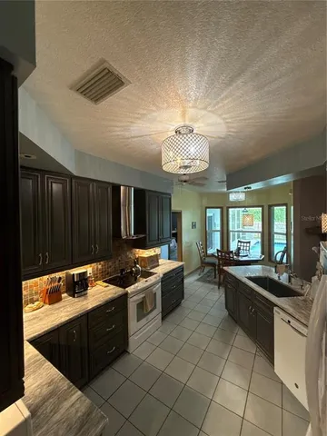 a large kitchen with stainless steel appliances granite countertop a stove and a sink