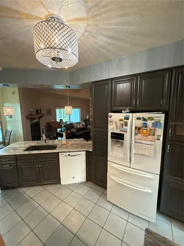 a kitchen with a refrigerator and white cabinets