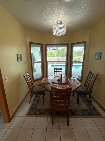 a view of a dining room with furniture a chandelier and wooden floor