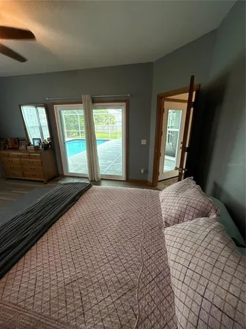 a bedroom with a bed lamp and a large window