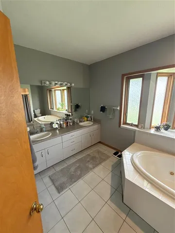 a large white tub sitting in a bathroom with a sink