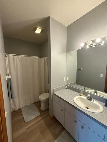 a bathroom with a double vanity sink toilet and a mirror