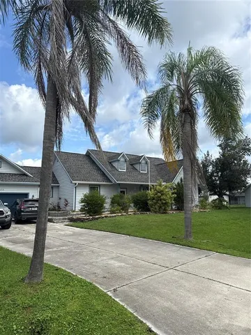 a front view of a house with a garden and trees