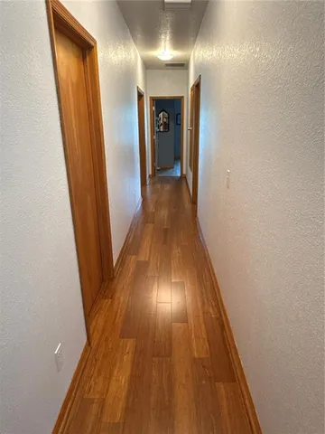 a view of a hallway with wooden floor