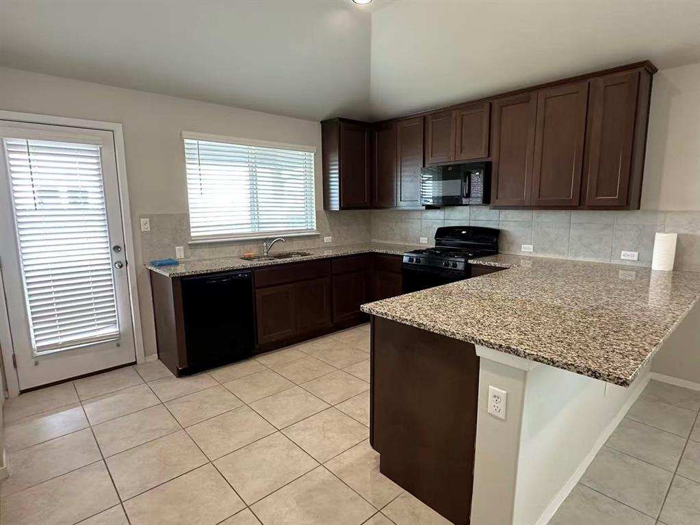 251 Tempest Trail Maxwell, TX 78656 - Photo 11 of 15 a kitchen with stainless steel appliances granite countertop a sink stove and a refrigerator
