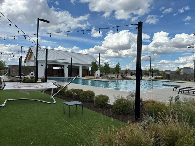 a swimming pool with outdoor seating and garden