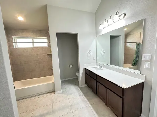 a bathroom with a double vanity sink and mirror with bathtub