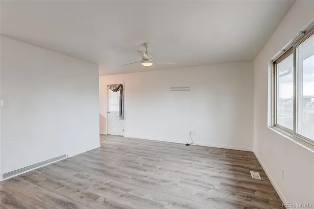 wooden floor in an empty room with a window