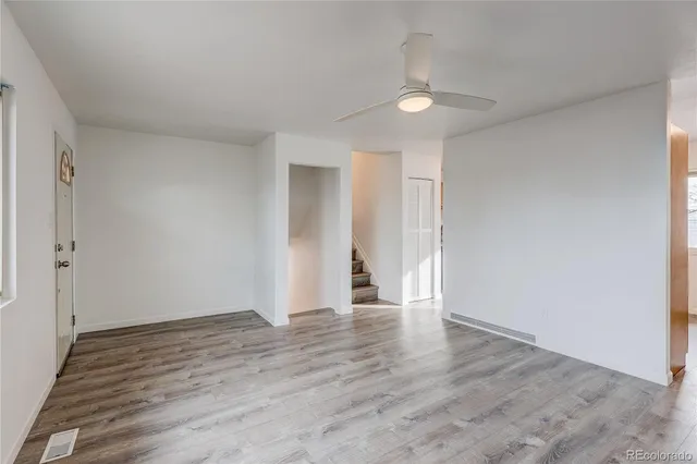 a view of an empty room with wooden floor