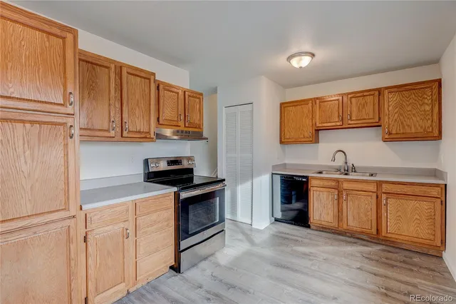 a kitchen with granite countertop wooden cabinets and a stove top oven