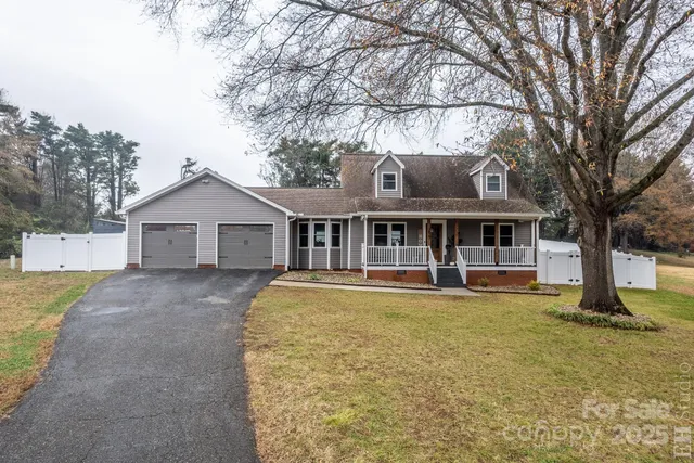 a front view of house with yard and trees in the background