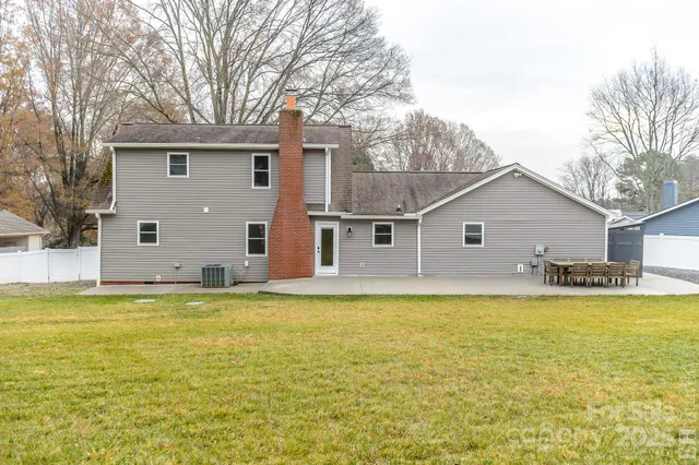 a view of a house with backyard and sitting area