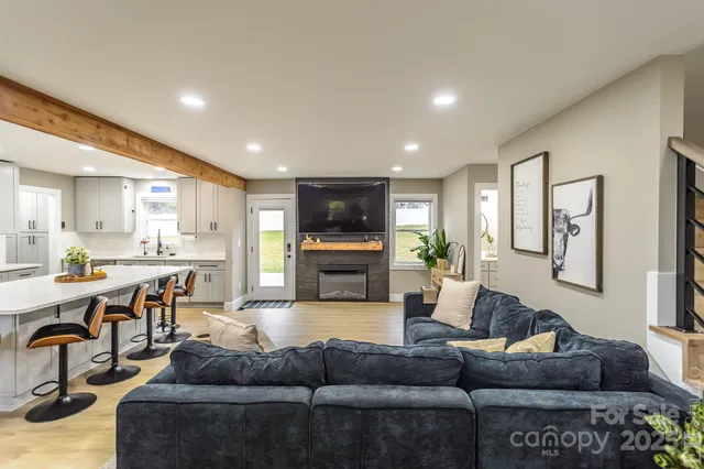 a living room with furniture kitchen view and a large window