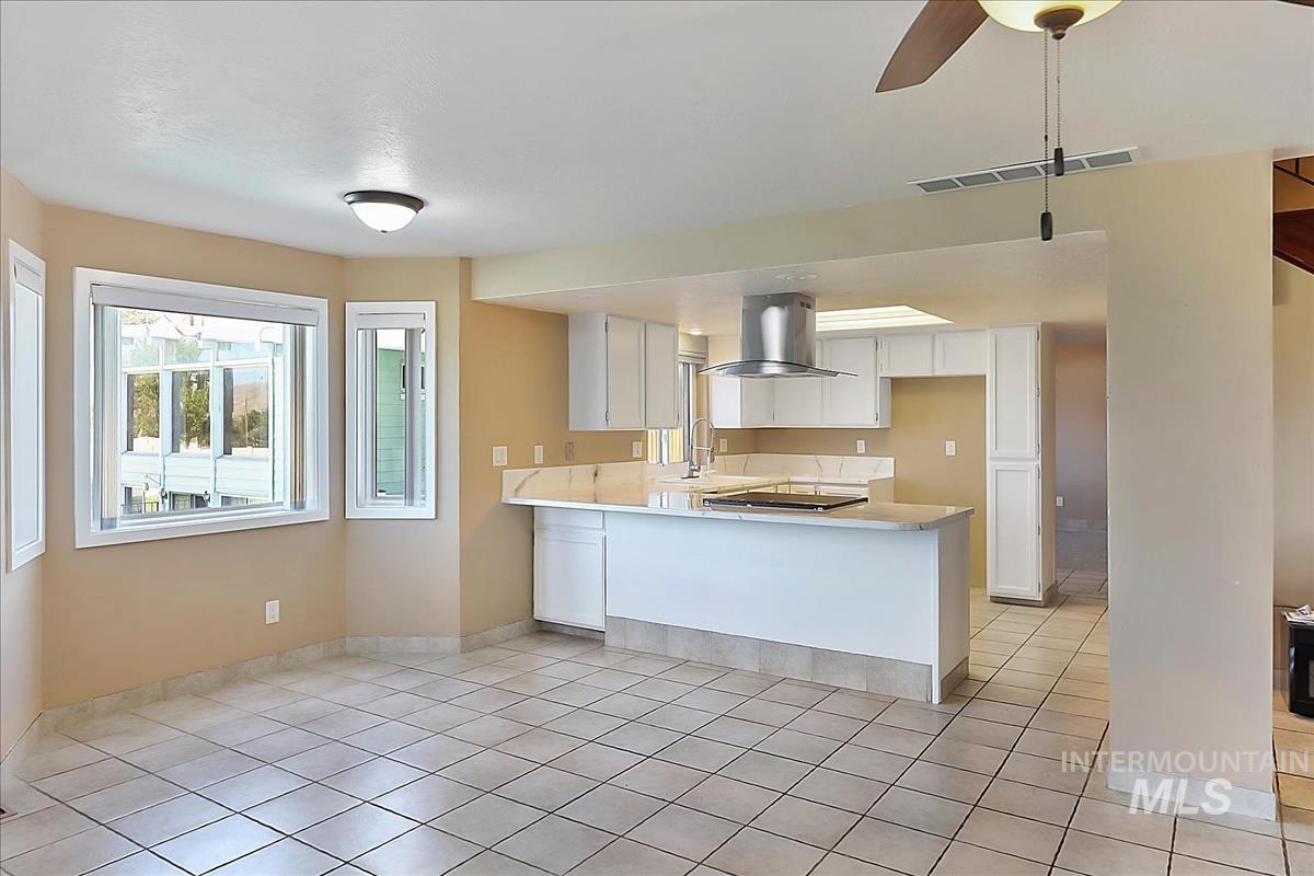 2804 West Sunrise Rim Road Boise, ID 83705 - Photo 17 of 50 Spacious open-concept kitchen and living area featuring tile flooring, white cabinetry, and light-toned countertops