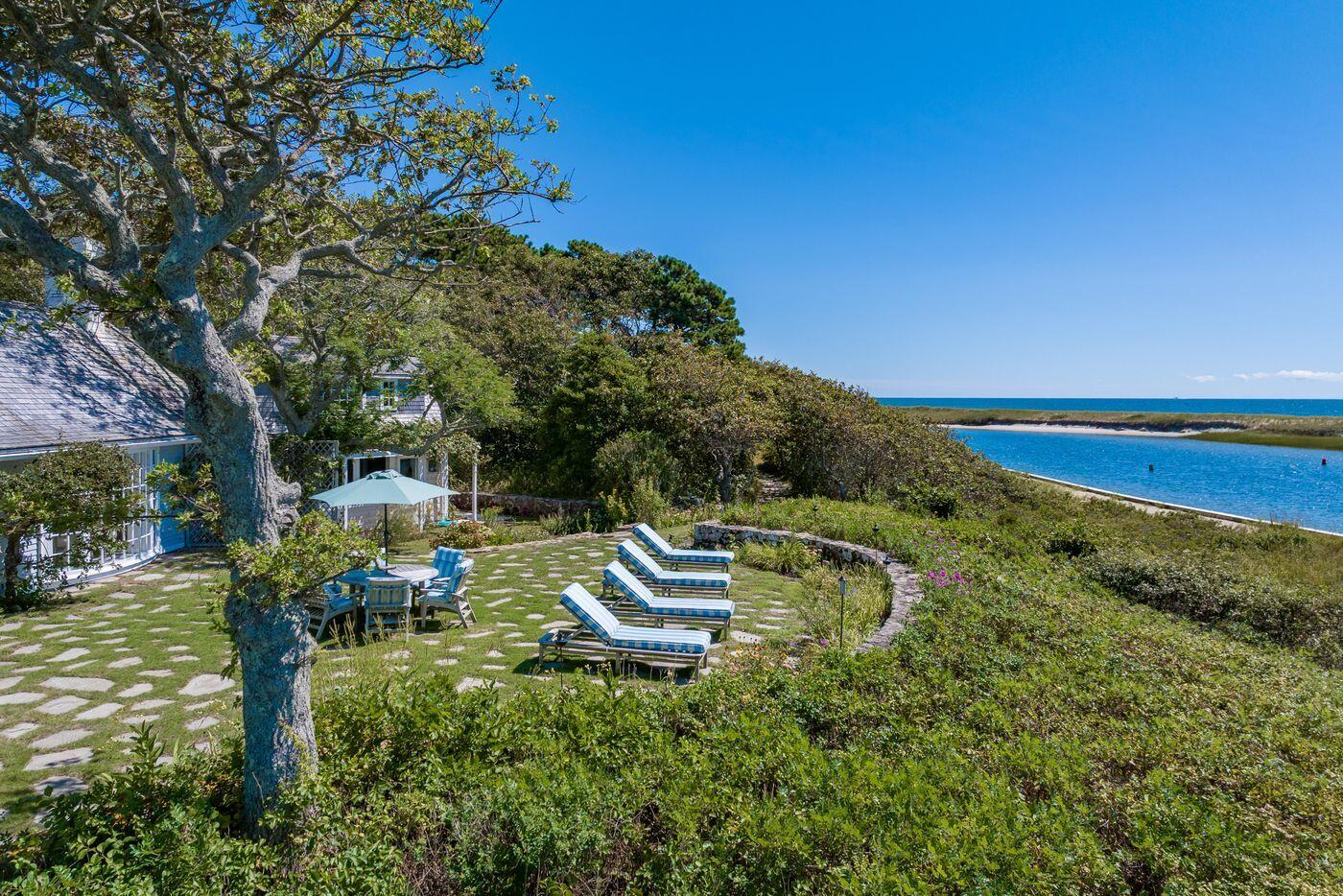 17 Indian Trail Osterville, MA 02655 - Photo 4 of 19 a backyard of a house with table and chairs