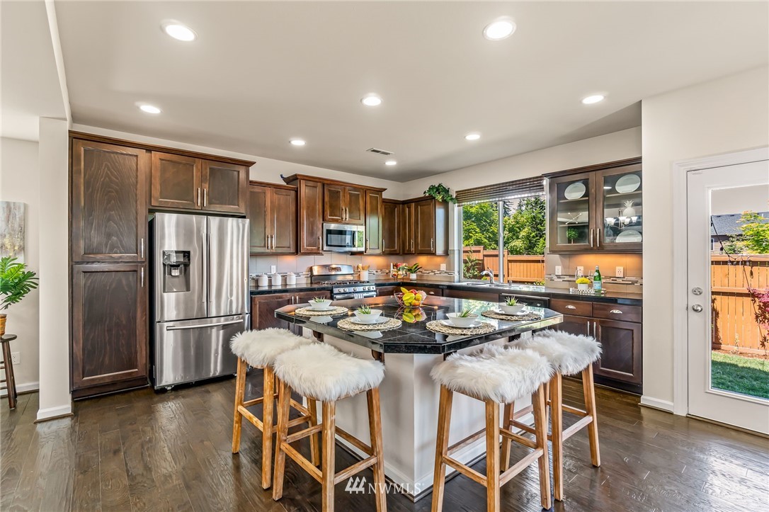 3527 198th Street Southeast Bothell, WA 98012 - Photo 11 of 40 a kitchen with stainless steel appliances granite countertop a refrigerator a stove top oven and a refrigerator