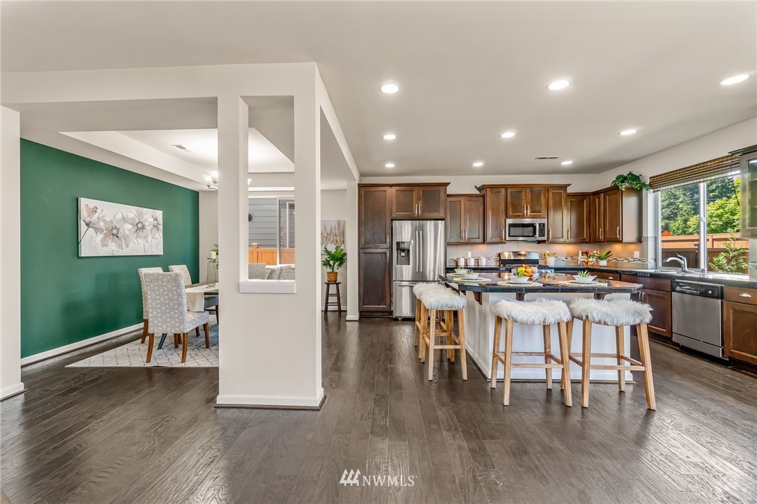 3527 198th Street Southeast Bothell, WA 98012 - Photo 10 of 40 a living room with stainless steel appliances kitchen island granite countertop furniture a dining table and chairs