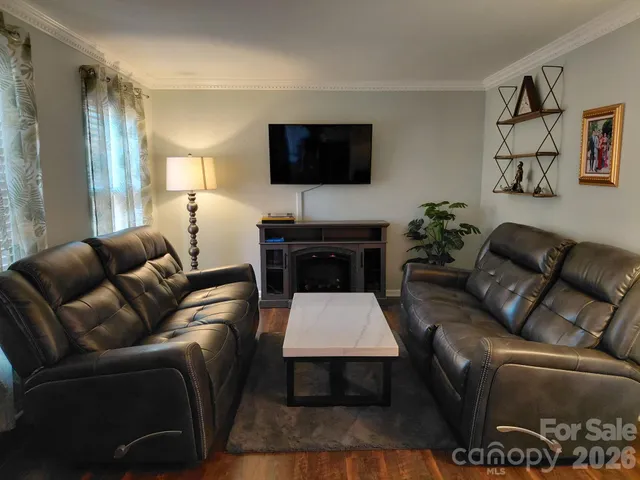 a living room with furniture a flat screen tv and a lamp