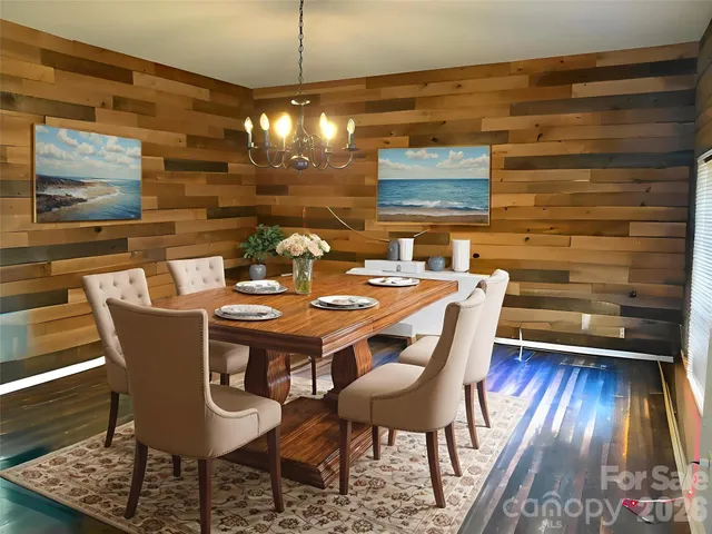 a dining room with furniture wooden floor a rug and a chandelier