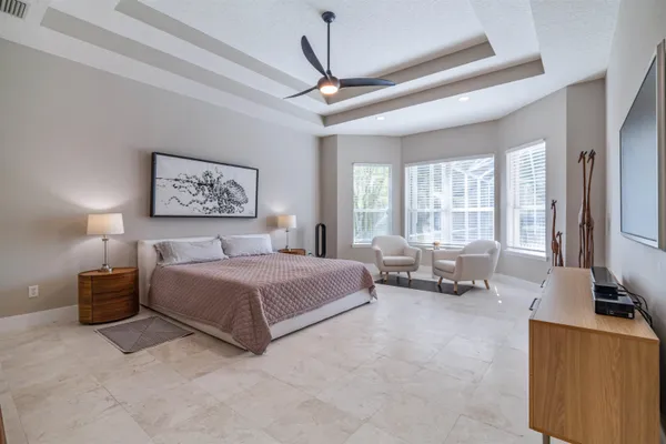 a spacious bedroom with a bed couch and a window