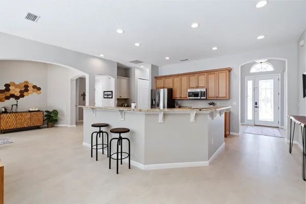 a large white kitchen with stainless steel appliances granite countertop a stove and a refrigerator