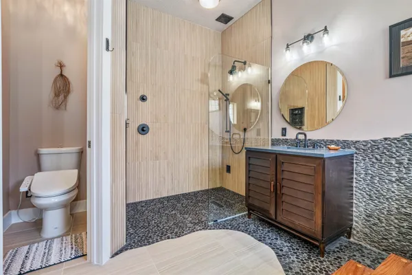 a bathroom with a sink a toilet and shower