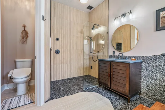 a bathroom with a sink a toilet and shower