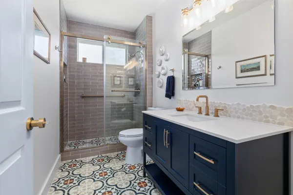 a bathroom with a sink toilet a mirror and shower