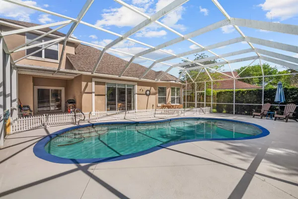 a view of a house with a swimming pool and sitting area