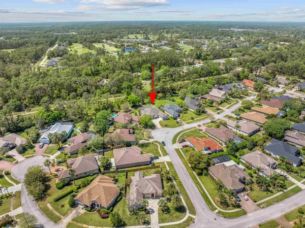 an aerial view of residential houses with outdoor space and trees
