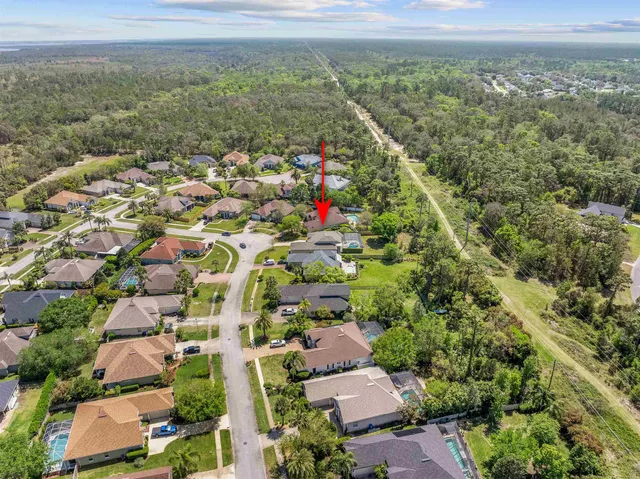 an aerial view of residential houses with outdoor space and trees