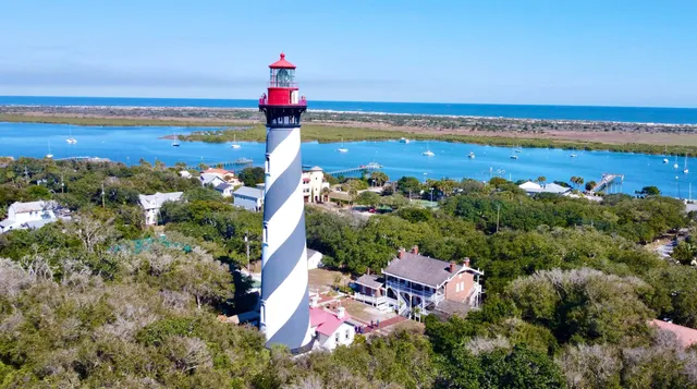 an aerial view of ocean and residential houses with outdoor space
