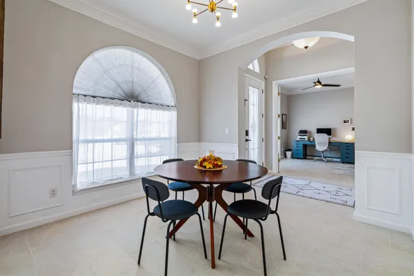 a view of a dining room with furniture and a chandelier