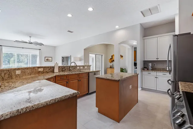 a kitchen with granite countertop a sink stove and refrigerator
