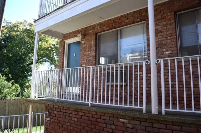 a view of a brick house with a porch