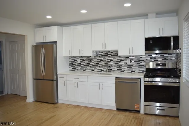 a kitchen with stainless steel appliances granite countertop a refrigerator stove and microwave