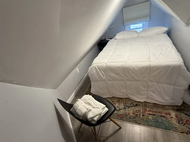 a bed sitting in a bedroom and wooden floor