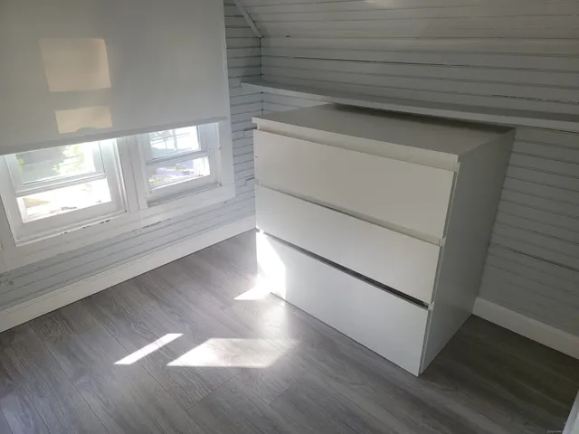 a view of empty room with window and wooden floor
