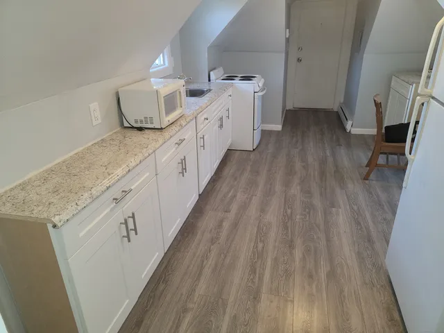 a spacious bathroom with sink and wooden floor