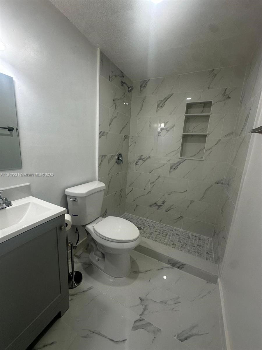 2753 West 68th Place Hialeah, FL 33016 - Photo 8 of 10 a bathroom with a toilet sink and shower
