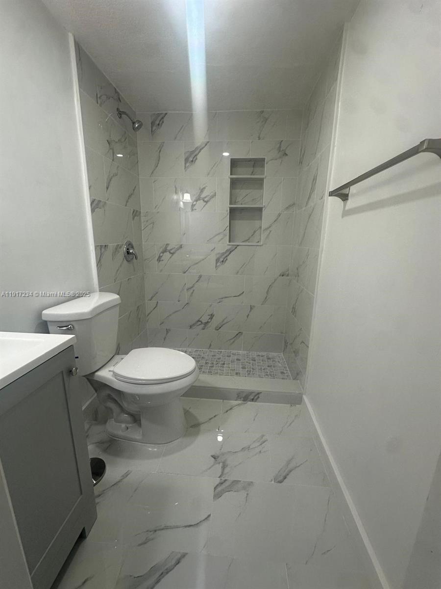 2753 West 68th Place Hialeah, FL 33016 - Photo 10 of 10 a white toilet sitting next to a bathroom sink and vanity