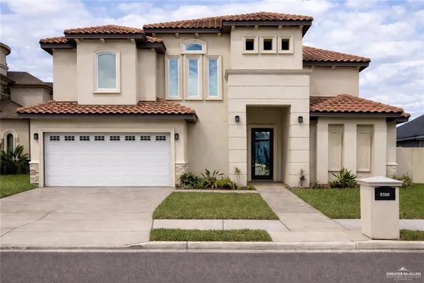 a front view of a house with a garden and garage
